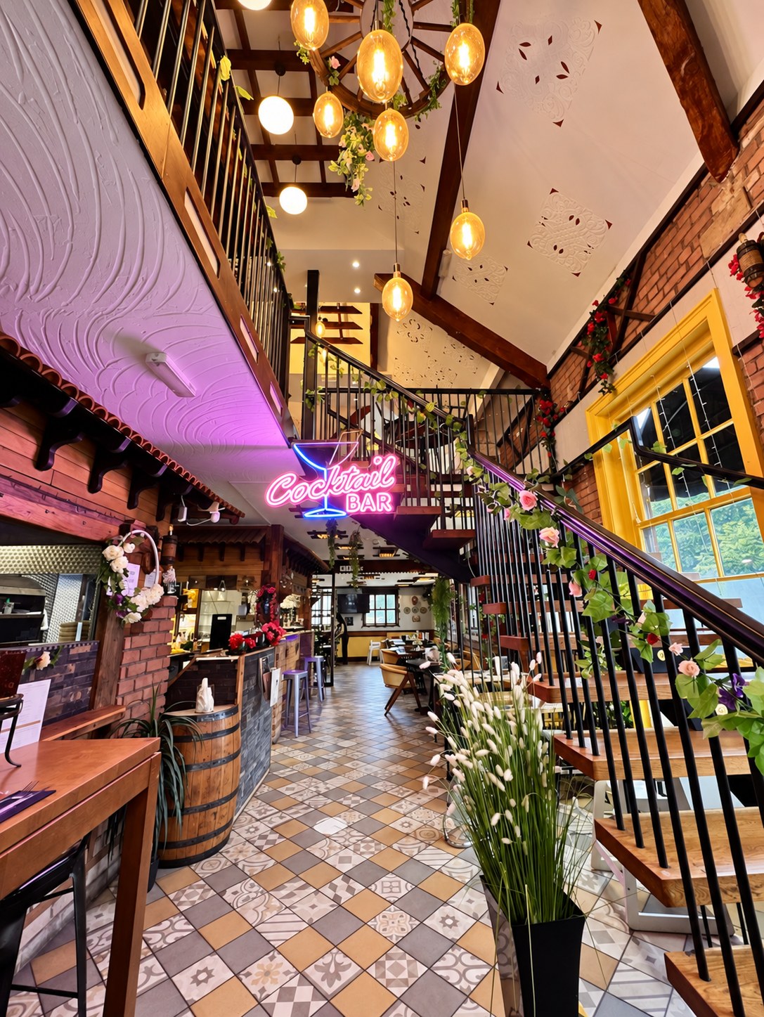Babylon interior with warm pendant lights, floral staircase and cocktail bar